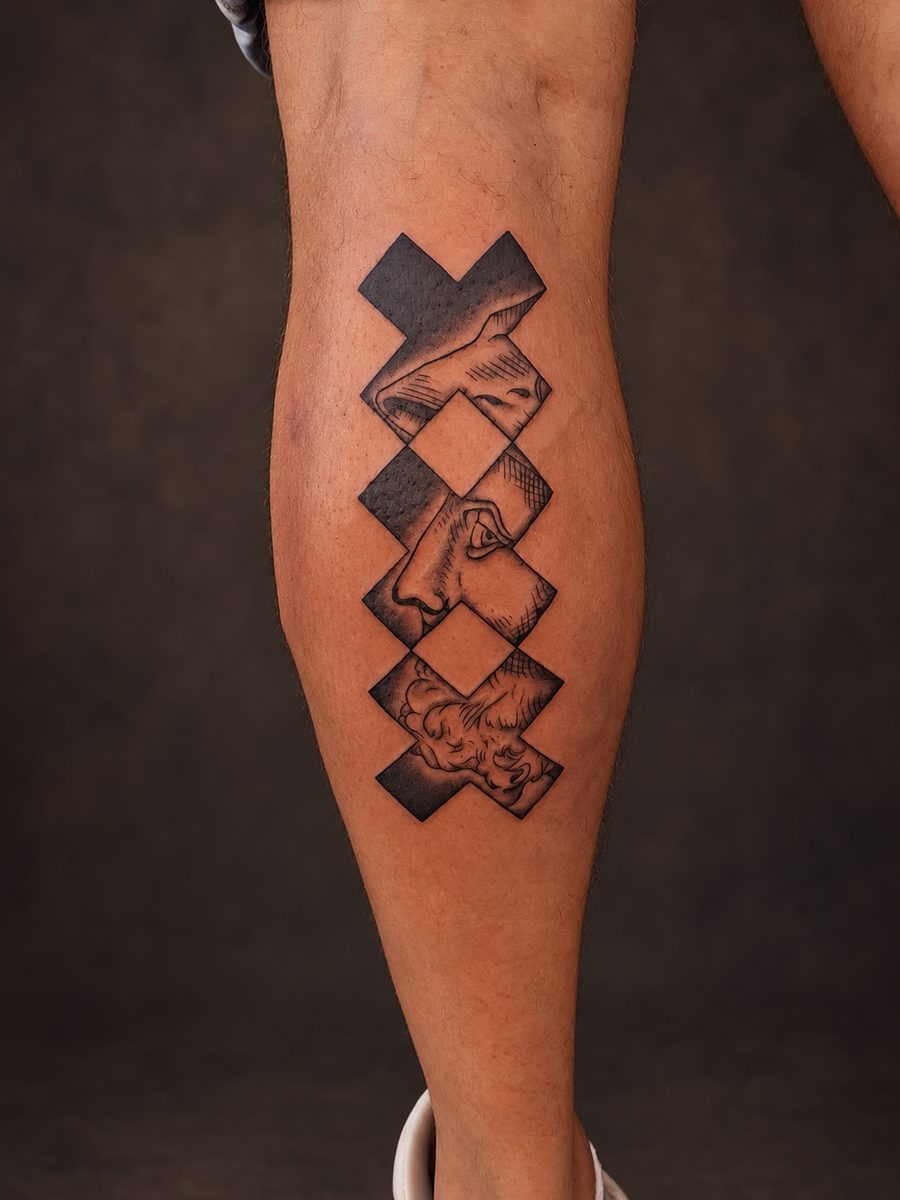 Blackwork tattoo van een geometrisch patroon in massief zwart op het been, gezet bij EmmsTattoo in Lelystad