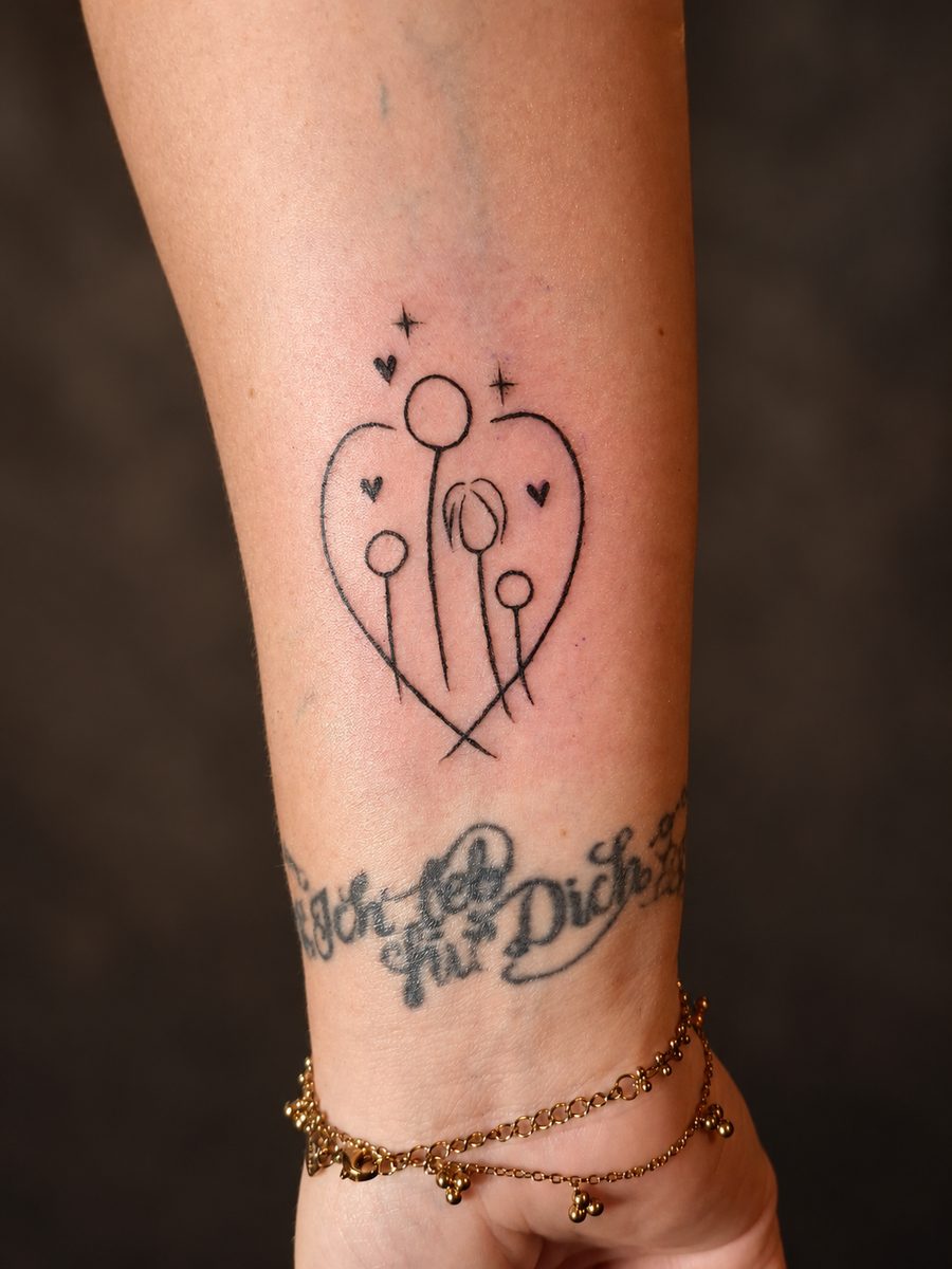 Fineline tattoo van fijne figuren met tekst rond de enkel, gezet bij EmmsTattoo in Lelystad