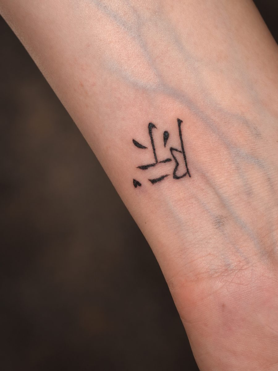 Fineline tattoo van een klein grafisch symbool op de onderarm, gezet bij EmmsTattoo in Lelystad