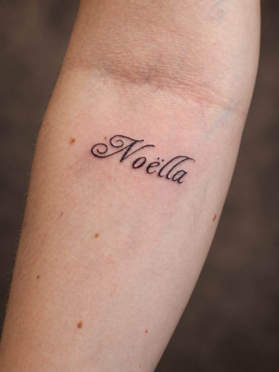 Fineline tattoo van een naam in handschrift op de onderarm, gezet bij EmmsTattoo in Lelystad