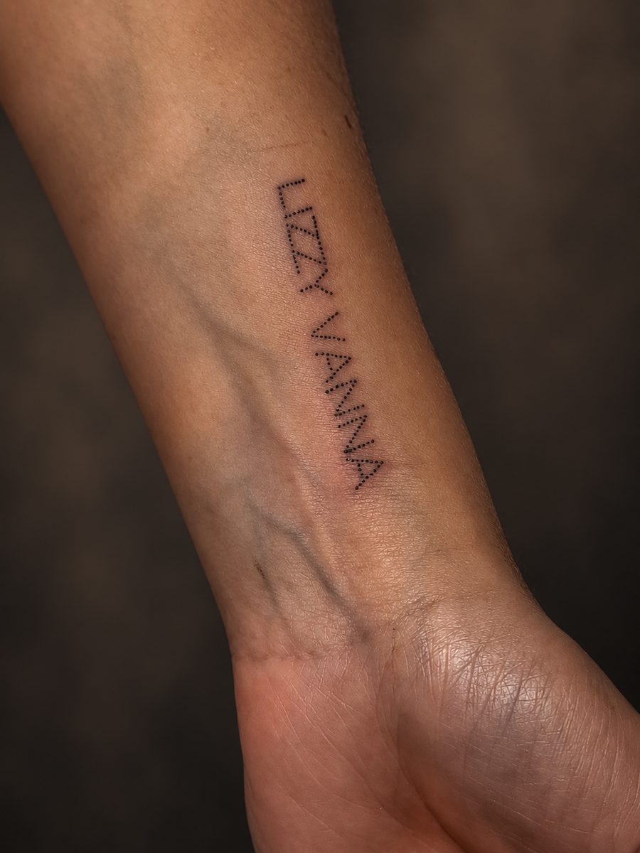 Fineline tattoo van een naam in sierlijke letters op de onderarm, gezet bij EmmsTattoo in Lelystad