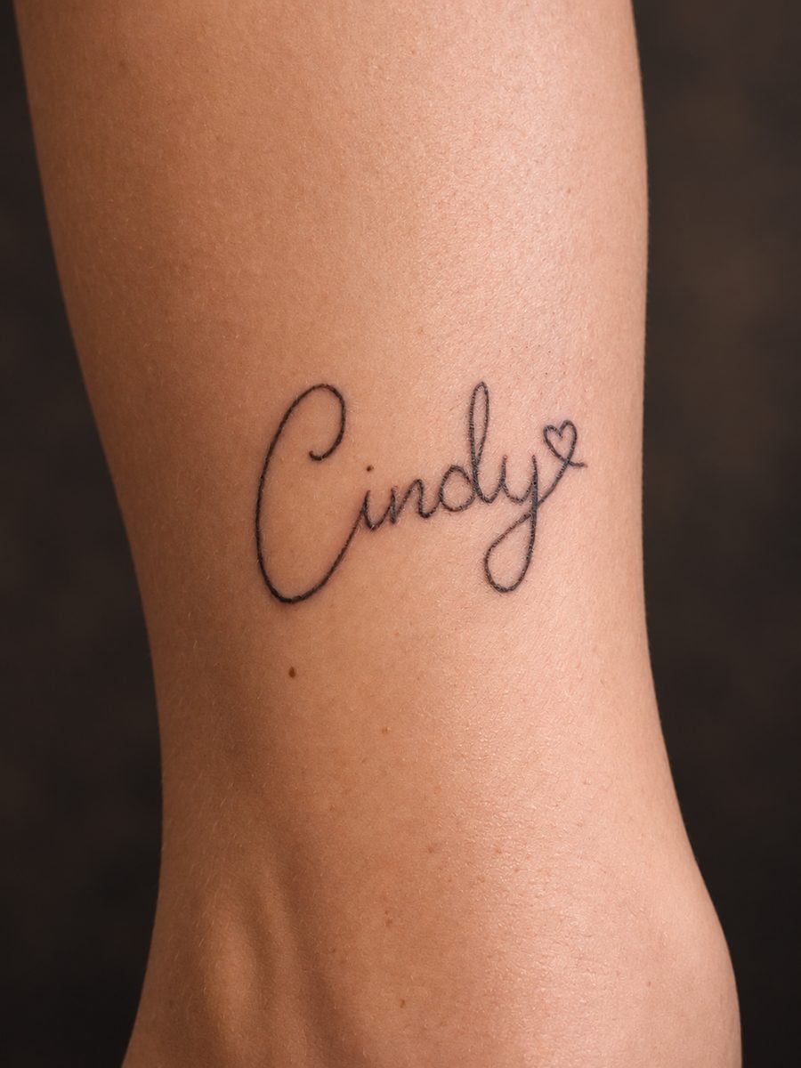 Fineline tattoo van een naam in handschrift op de ribben, gezet bij EmmsTattoo in Lelystad