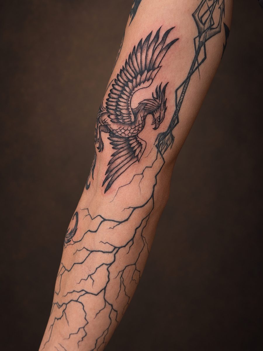 Illustrative tattoo van een draak in fijn lijnwerk over de onderarm, gezet bij EmmsTattoo in Lelystad
