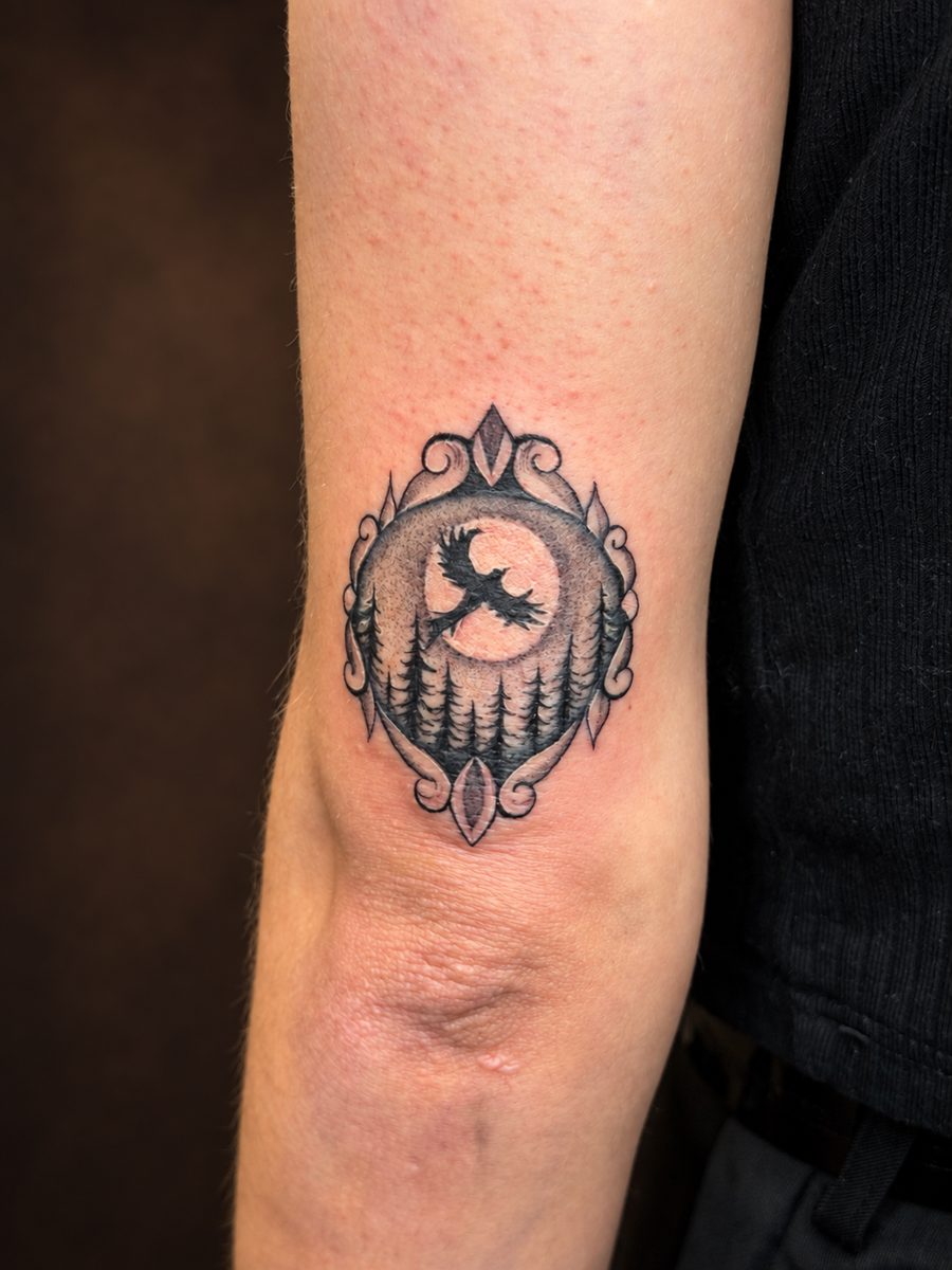 Illustrative tattoo van een ingelijst ornament met maan op de bovenarm, gezet bij EmmsTattoo in Lelystad